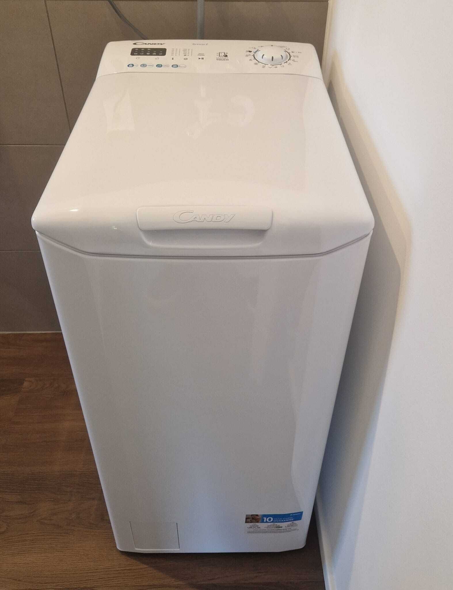 A white Candy brand front-loading washing machine with a digital control panel and a touchpad.