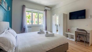 Une chambre d’hôtel moderne avec un grand lit, un bureau et une télévision.
