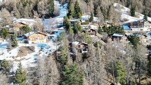 Un paisaje montañoso con varias cabañas de madera rodeadas de árboles y nieve.