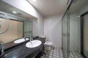 A modern bathroom with two sinks, a toilet, and a glass-enclosed shower. - Shanghai Lijingyuan Hotel (Shanghai)