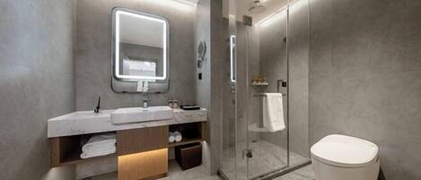 A modern bathroom with a glass-enclosed shower, a large mirror, and a white toilet.