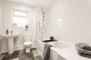 A modern bathroom with a toilet, sink, shower, and bathtub. - Spacious 3BR in Blyth | Sleeps 6 | By Stay With Us (Northumberland)