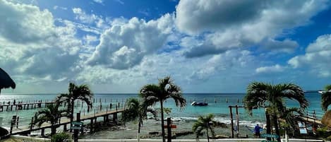 Enjoy stunning ocean views from our beachside hotel, with a pier stretching into the water and a pool area nearby.