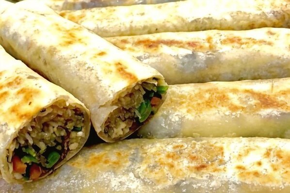 Une vue rapprochée d’un plat, vraisemblablement un burrito, dont on peut voir la garniture.