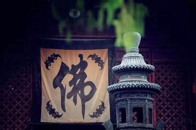 Eine traditionelle Laterne mit Kalligraphie, eine Wand mit Muster und ein hängendes Banner.