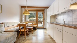 A modern kitchen with wooden cabinets and a dining area with a wooden table and chairs.