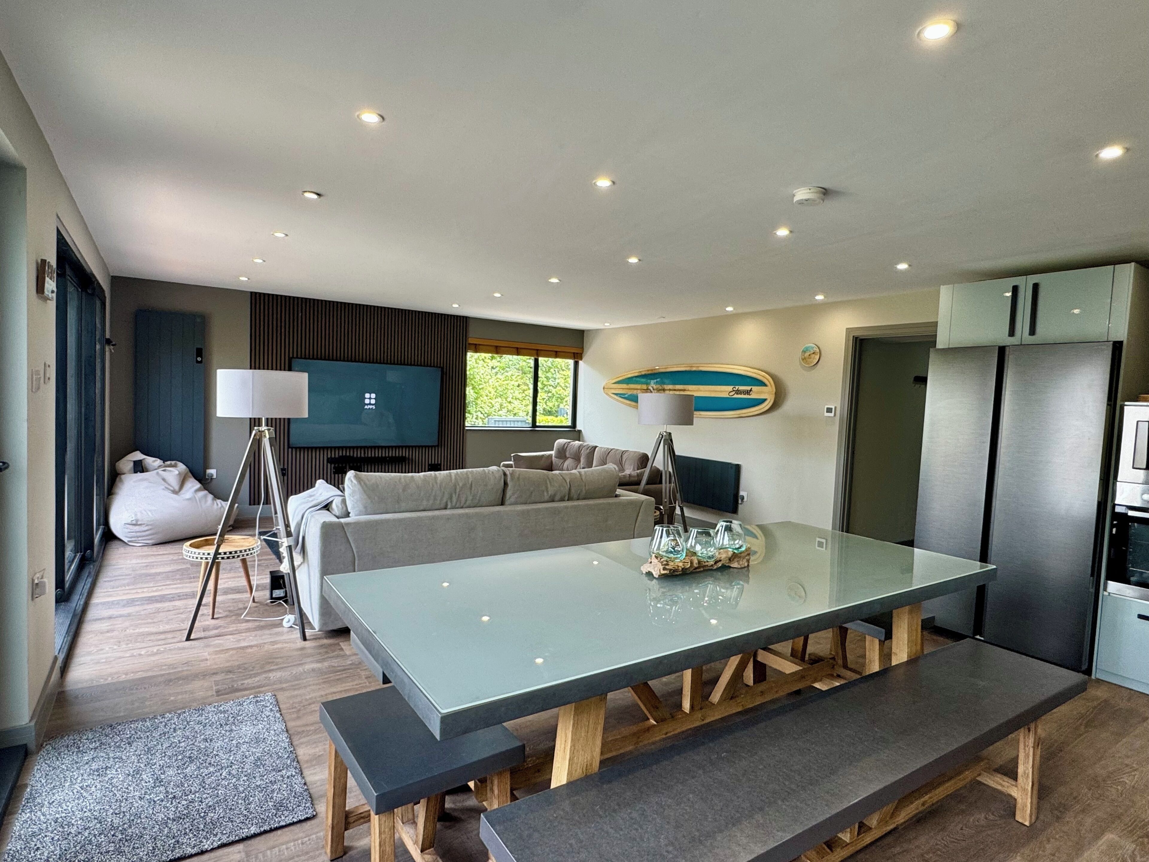 Una cocina moderna con una mesa de comedor, un sofá y un televisor.