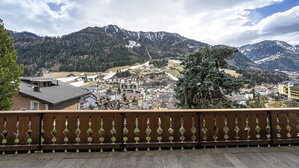 Une ville située au pied d’une montagne, avec des balcons en bois et une vue sur des maisons et des immeubles.