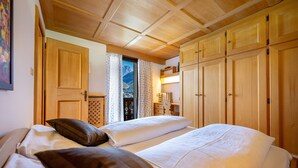 Une chambre avec deux lits, des armoires en bois et une fenêtre avec des rideaux.