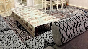 A bedroom with a bed, a sofa, a dining table with chairs, a chandelier, a TV, and a wardrobe. - Samarqand Same Hotel (Samarkand)