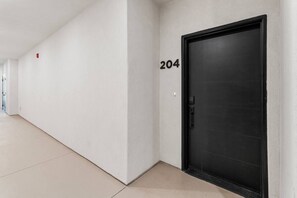 A hallway with a black door marked with the number 204.