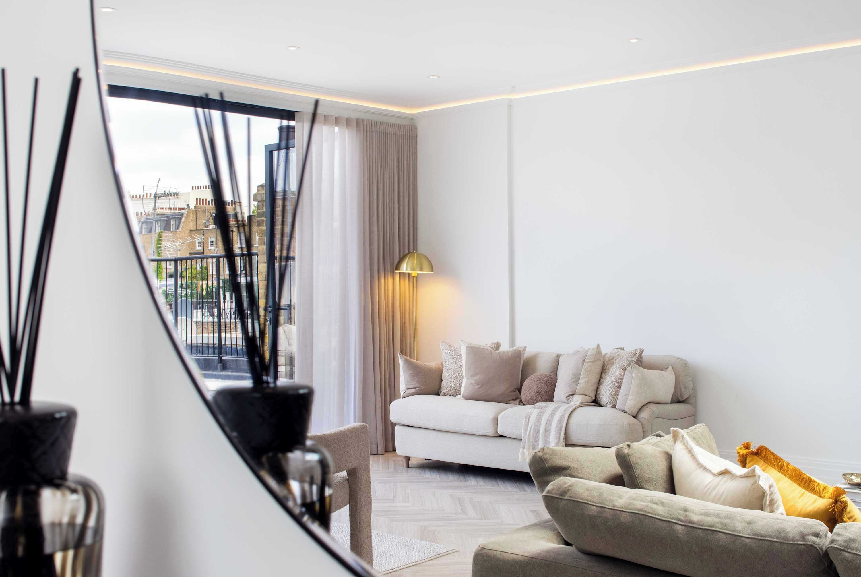 Un salon moderne avec un canapé, une lampe et une vue par la fenêtre.