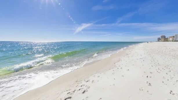 A beach with a clear sky and a bright sun. - Island Winds West 471 (Gulf Shores)