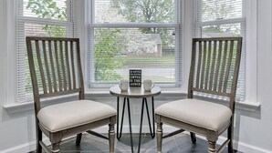 Two wooden chairs with cushioned seats and a small table with a sign between them. - 4 Bedroom Beachside Retreat – High - Speed WiFi Included (Virginia Beach)