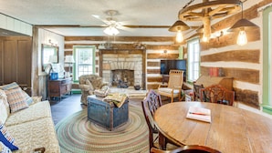 A rustic interior with a stone fireplace, wooden furniture, and a cozy seating area. - Hot Tub & Creek Views: Secluded Perryville Cabin (Perryville)