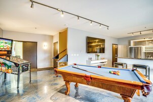 Una mesa de billar en una sala de estar moderna con un televisor de pantalla plana y una mesa de billar con temática de South Park.