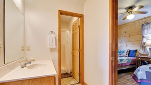 Een badkamer met een houten wastafel, een spiegel en een douche.