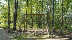 A forest with a wooden swing set. - Private Dock & Deck: Tranquil Dam Pond Cottage! (Augusta)