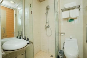 A bathroom with a glass shower enclosure, a sink, and a toilet. - Shell Hotel (Xinxiang Pang Donglai Branch) (Xinxiang)
