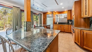 A modern kitchen with granite countertops, wooden cabinets, and a large island. - Spacious 4,000 Sq Ft Riverfront Home | Game Room • Deck • 1.5 Miles to Keystone (Keystone)