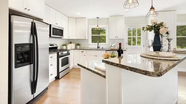 A modern kitchen with white cabinetry, stainless steel appliances, and a granite countertop. - Family Retreat - 3-bedroom unit with NEW Pool, WiFi and AC in North Durham (Durham)