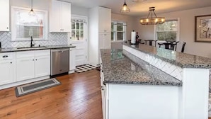 A modern kitchen with white cabinetry, granite countertops, and pendant lighting. - Family Retreat - 3-bedroom unit with NEW Pool, WiFi and AC in North Durham (Durham)