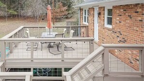 A multi-level deck with a table and chairs, a covered seating area, and a staircase. - Family Retreat - 3-bedroom unit with NEW Pool, WiFi and AC in North Durham (Durham)