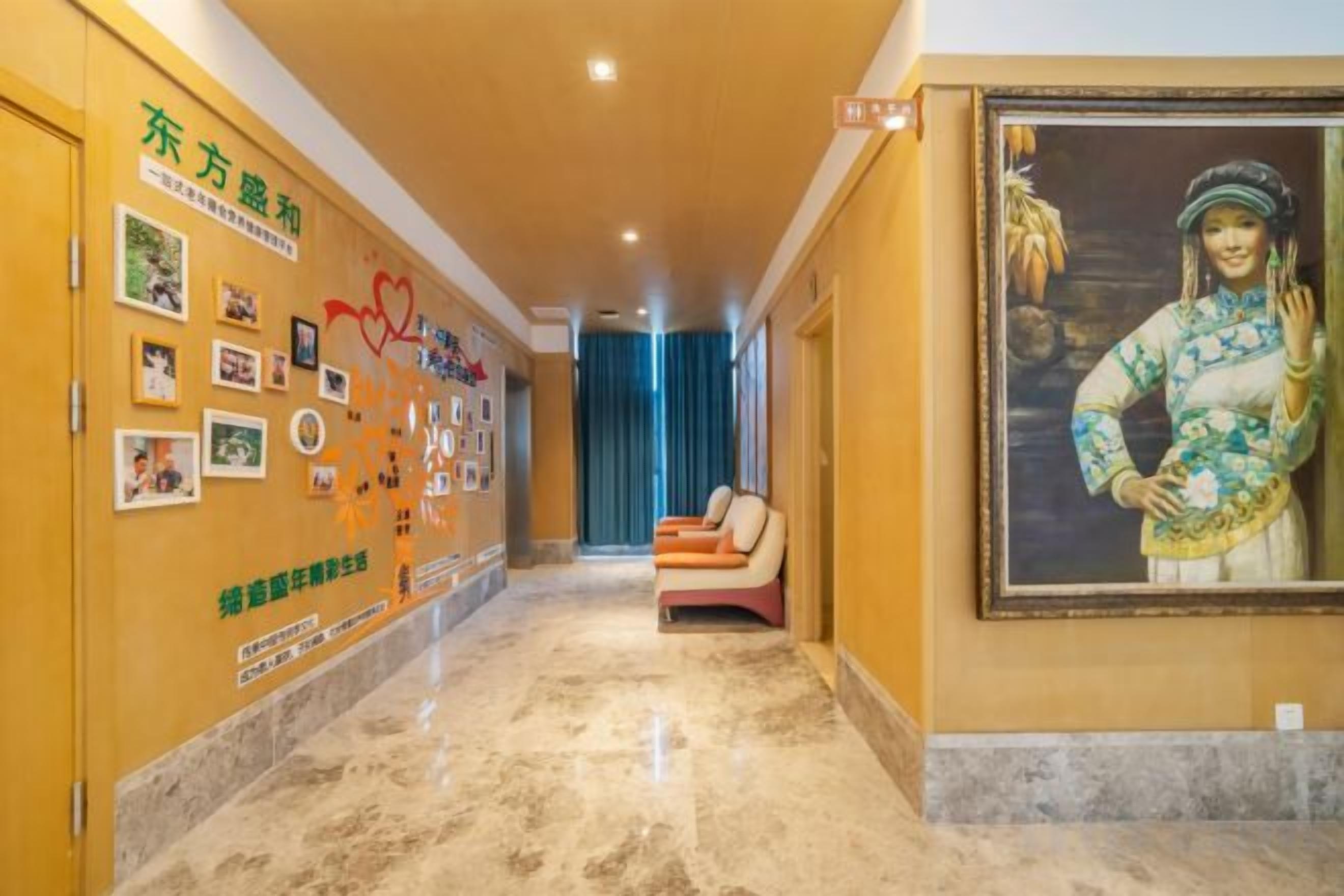 Un pasillo de hotel con piso de mármol, una zona de estar con cojín y un cuadro grande en la pared.