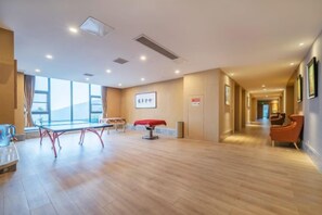 A hotel room with a large bed, a desk, and a chair. There is a window providing natural light and a view of the outdoors. - Tianxiangyuan Hotel (Beiqi Yunshan Branch) (Chongqing)