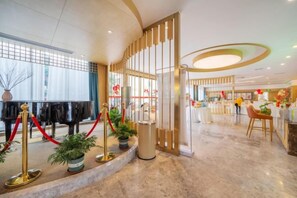 A hotel lobby with a grand piano, red ropes, potted plants, and a reception desk. - Tianxiangyuan Hotel (Beiqi Yunshan Branch) (Chongqing)