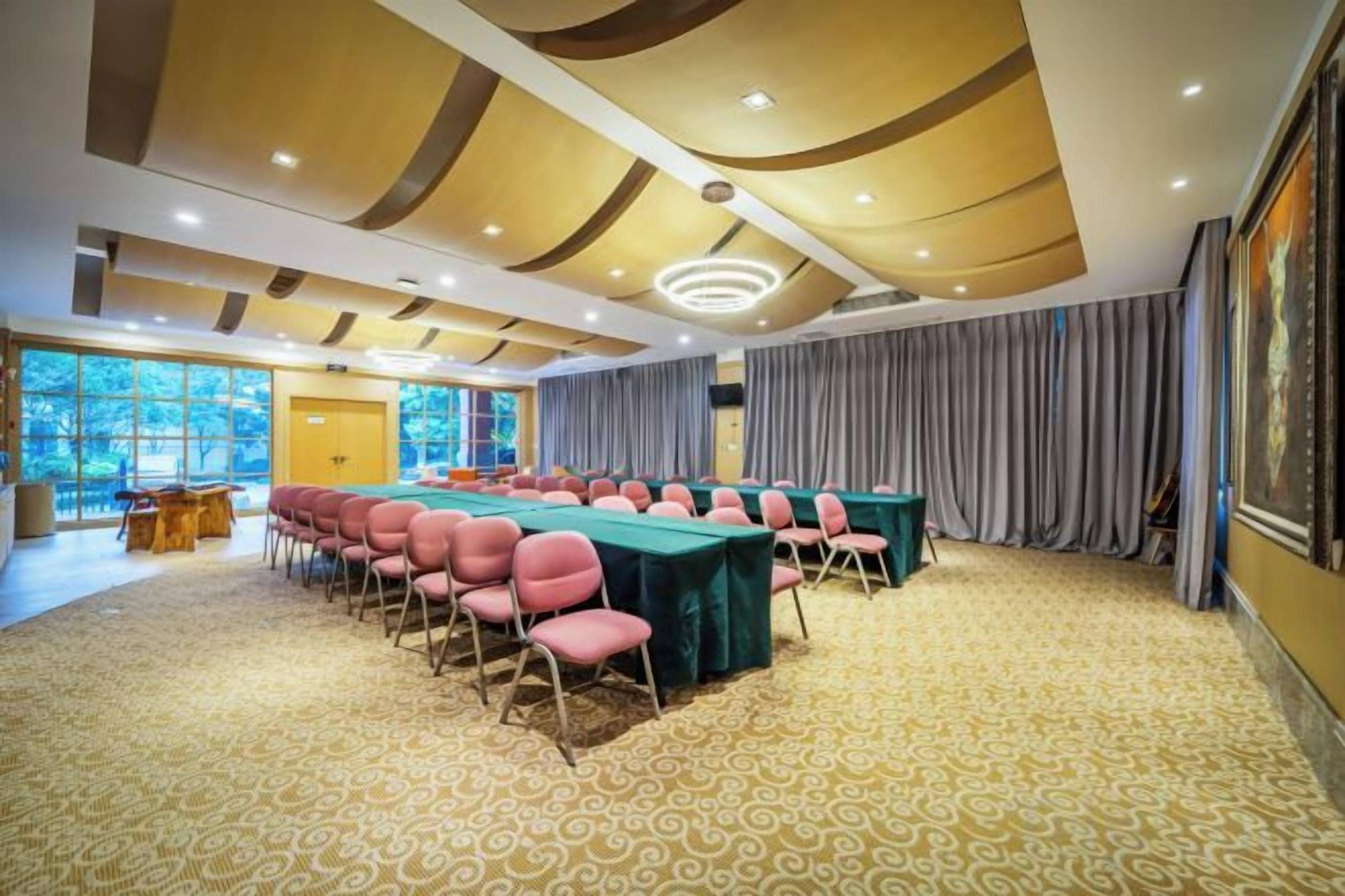 Un salón de conferencias con una larga mesa, sillas y una alfombra estampada.