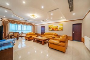 A spacious living room with a large sectional sofa, a wooden coffee table, and a television.