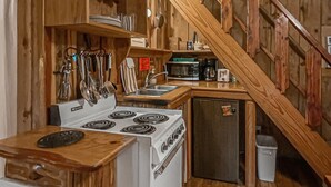 Une cuisine de taille réduite, avec des meubles de rangement en bois, une cuisinière et un évier.