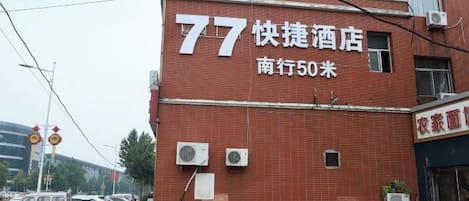 Un edificio de ladrillo con un letrero que indica '77' y 'Quick Hotel'.
