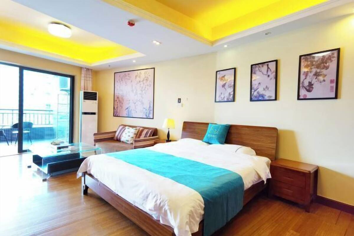 Een moderne hotelkamer met een groot bed, een nachtkastje en een raam met uitzicht.