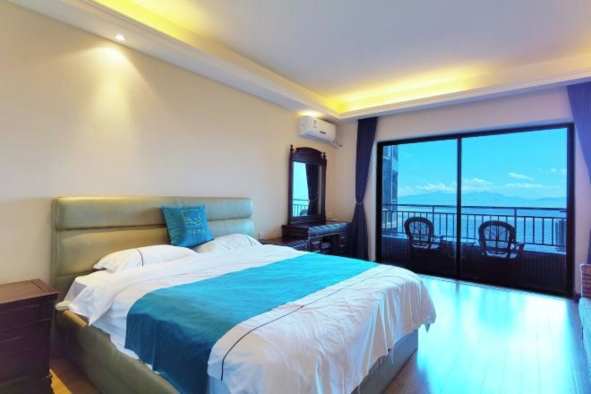 Une chambre d’hôtel avec un lit, un bureau, une chaise et un balcon offrant une vue.