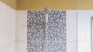 A shower with a mosaic tile wall. - Good and Homey Studio at Student Park Yogyakarta Apartment (Depok)