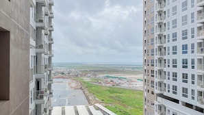 Un edificio de gran altura con múltiples balcones y vistas a un paisaje lejano.
