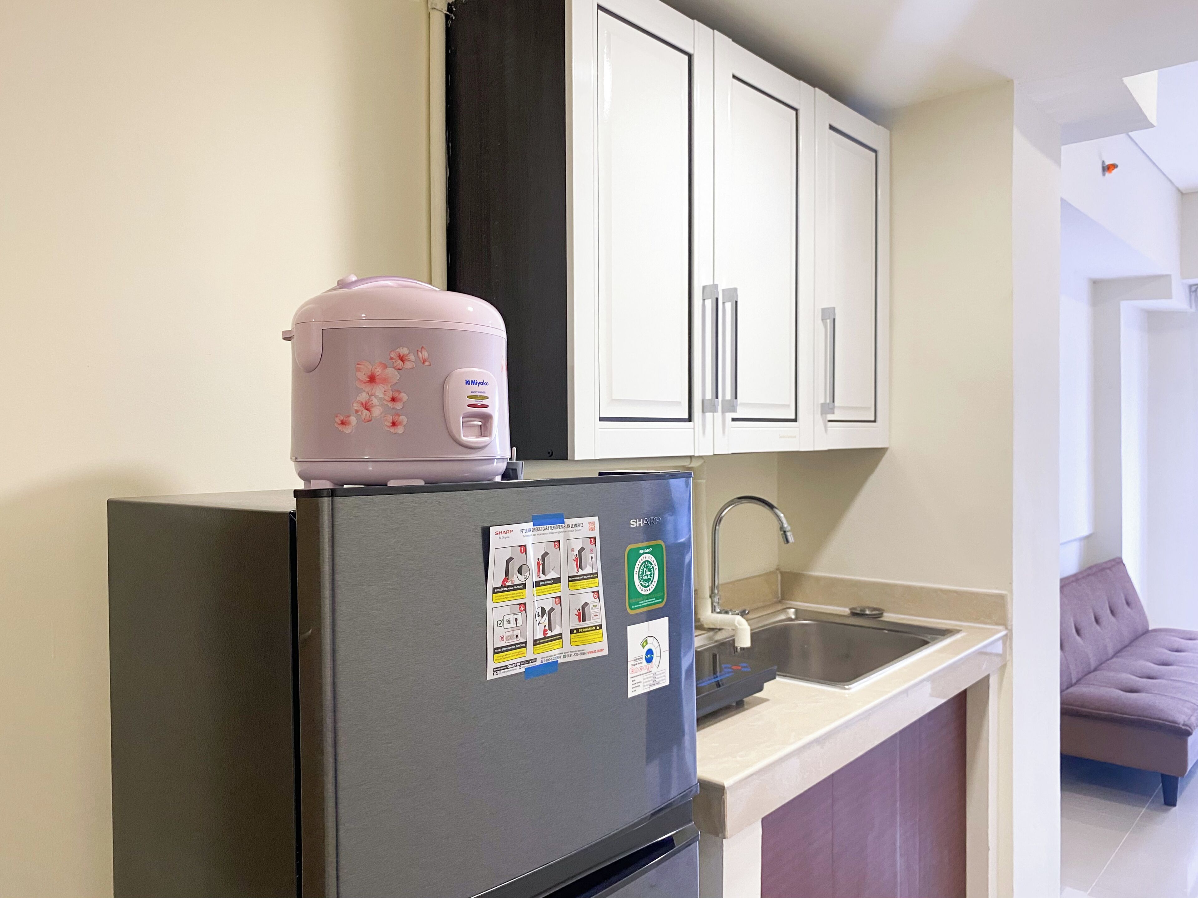 A kitchen with a refrigerator, a microwave, and a sink.