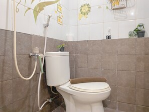 A bathroom with a toilet, shower, and decorative tiles. - Good Deal and Comfy 2BR Apartment Green Pramuka City (Jakarta)