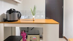 A kitchen with a countertop, a potted plant, a gas cylinder, and a trash bin. - Minimalist And Cozy 1BR at Royal Heights Apartment (Bogor)
