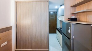 Une cuisine avec des meubles de rangement en bois, un réfrigérateur noir et un plan de travail.