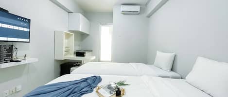 A modern hotel room with a bed, a TV mounted on the wall, a wardrobe, and a window.