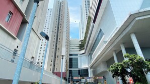 A modern urban building with multiple floors, large windows, and a prominent entrance with a glass facade.