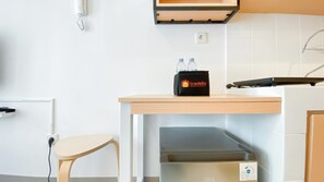 Une cuisine avec une table en bois, un sac noir portant l’inscription « travelio » et un appareil de la marque GEA.