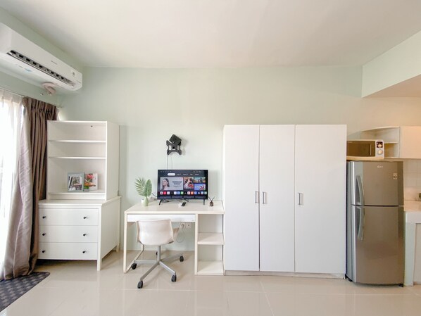 A modern kitchen with a built-in microwave, a stainless steel refrigerator, and a white cabinet. - Contemporary Designed Studio Apartment Park View Condominium (Depok)