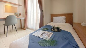 Une chambre d’hôtel avec un lit, un bureau et une chaise.