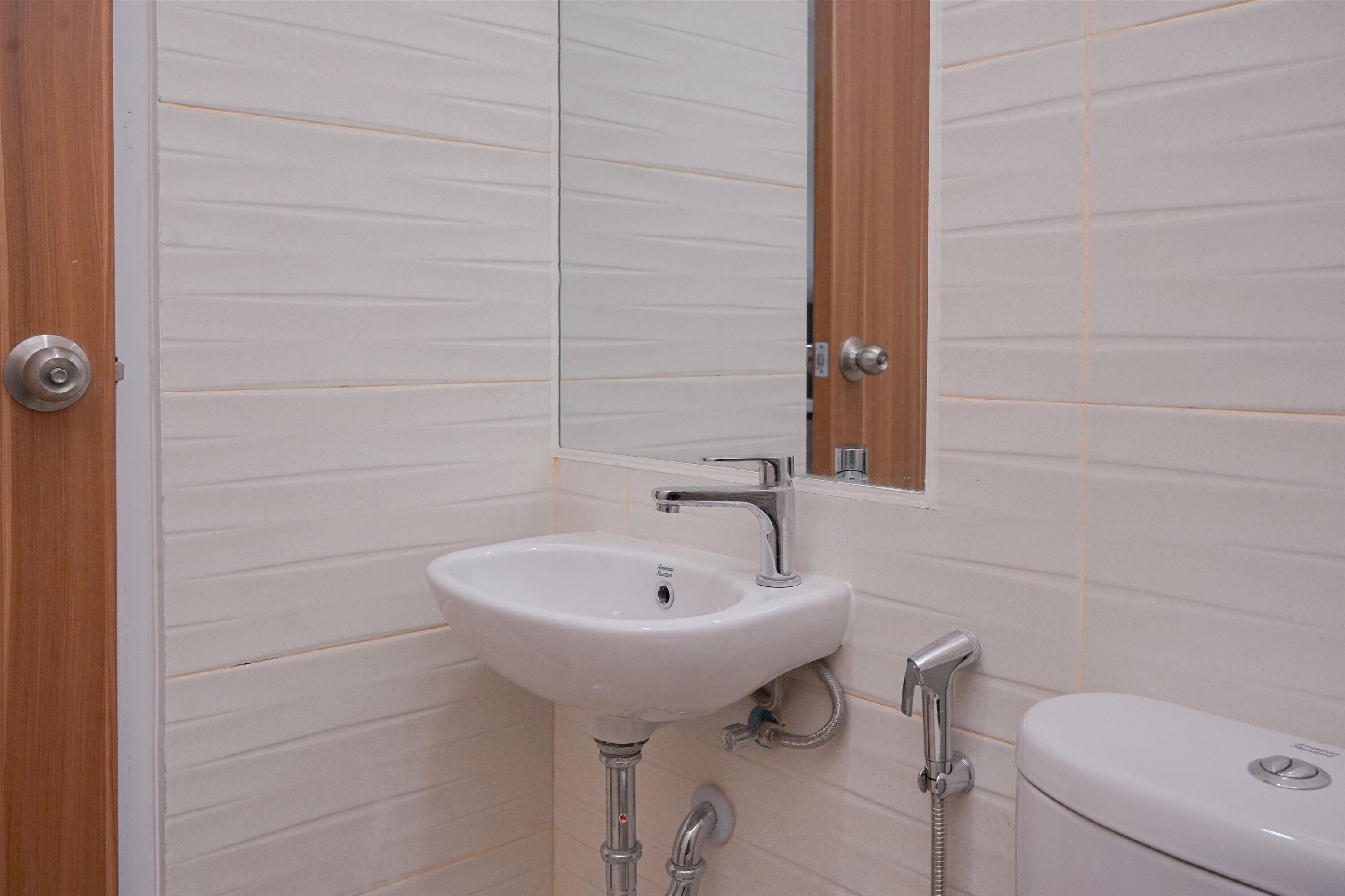 A bathroom with a white sink, a mirror, and a toilet.