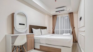 Ein modernes Hotelzimmer mit Bett, Schreibtisch und Spiegel.