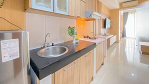 Een moderne keuken met roestvrijstalen apparatuur, houten kastjes en een zwart aanrecht.